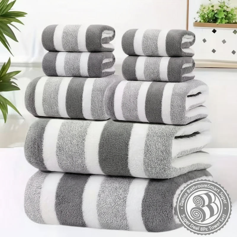 Stack of gray and white striped towels on a white surface with a blurred indoor background.