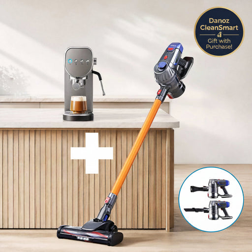 A cordless stick vacuum cleaner with an orange handle and dark gray and blue head is shown in a bright kitchen setting, with a coffee machine on the counter and a circular inset showing additional head attachments.
