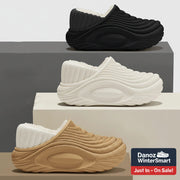 Three pairs of slippers in black, white, and beige on a neutral background