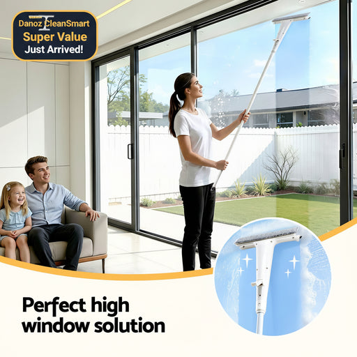 Woman cleaning a high window with a squeegee, with a man and child watching indoors.
