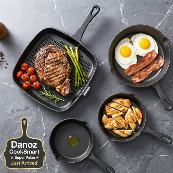 Set of black cast iron skillets with cooked food on a gray marble surface