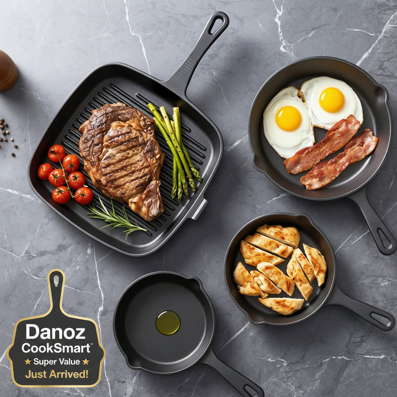 Set of black cast iron skillets with cooked food on a gray marble surface
