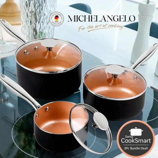 Set of black cookware with copper interior and glass lids on a reflective surface, featuring Michelangelo brand logo.