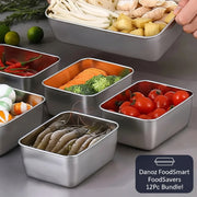 Set of stainless steel containers with various food items on a gray surface