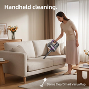 Woman using Danoz CleanSmart handheld vacuum to clean a sofa seam