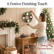 Woman styling a compact Christmas wreath above an oak console