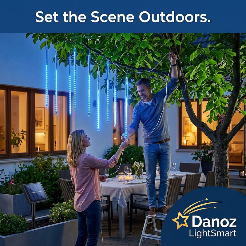 Couple setting up blue solar lights above an outdoor dining area