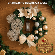 Champagne Christmas wreath flowers baubles foliage bow and lantern detail on oak