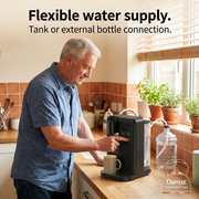 Older man using a compact InstaHotSmart dispenser with external water bottle connection