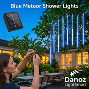 Woman fastening blue meteor light cable with solar panel inset