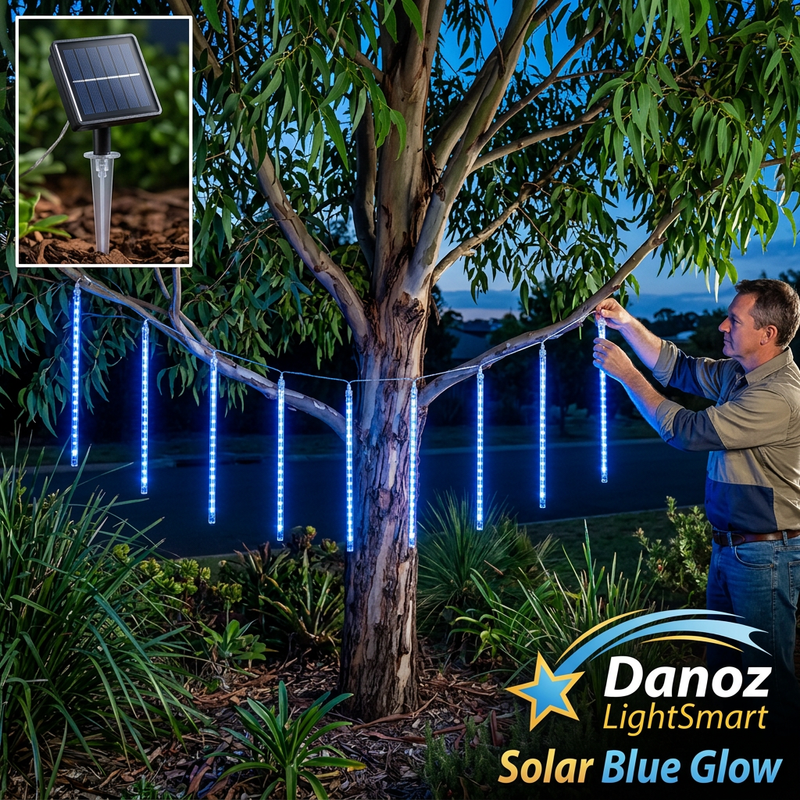 Man attaching blue meteor lights to tree branches with solar panel detail