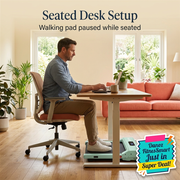 Man seated at desk with chair wheels on floor and walking pad paused under desk