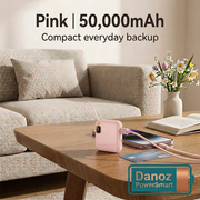 Compact Pink 50,000mAh PowerSmart power bank beside a phone on a living-room table