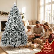 Family wrapping gifts beside snow-flocked fir tree
