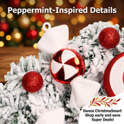 Peppermint-inspired ornament and red glitter-look baubles on frosted foliage