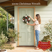 Woman hanging a compact ChristmaSmart Christmas wreath on a sage front door, Free Postage