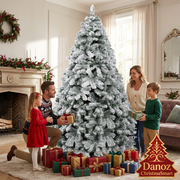 Family exchanging Christmas gifts beside snow-flocked tree