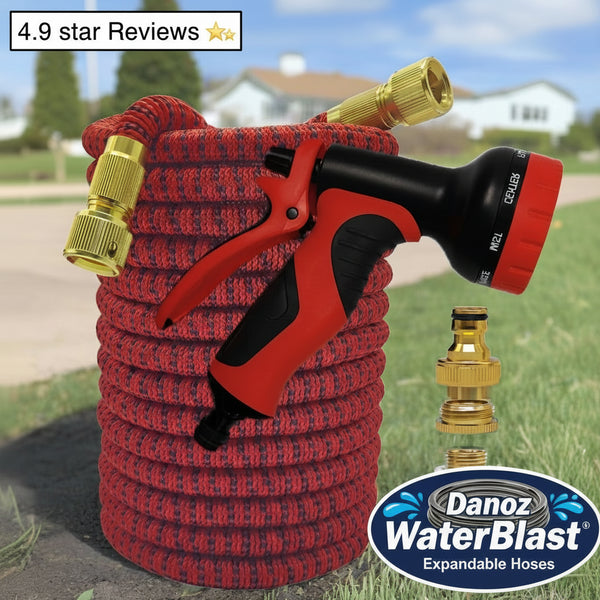 Red garden hose with black and red nozzle and gold connectors on grass