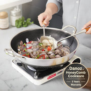 A stainless steel double-sided honeycomb non-stick wok with a lid being used on a stove, cooking stir-fried food.