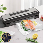 A food vacuum sealer machine with a piece of fish, a lemon, and some herbs wrapped in a vacuum-sealed bag on a kitchen counter.