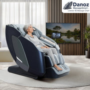 A modern electric massage chair with an LED touch screen, situated in a cozy living room setting, is grey in color and appears to have multiple massage settings.