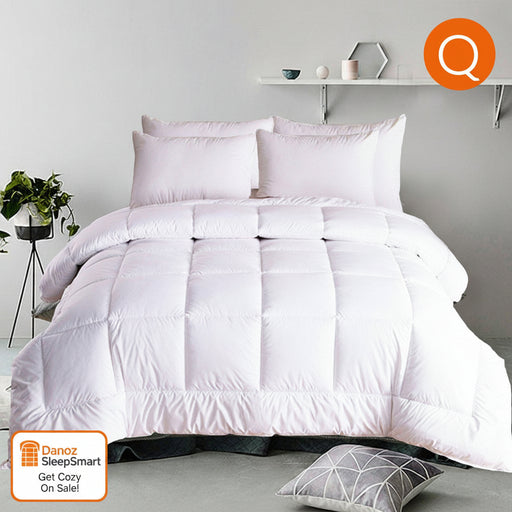 A white down alternative quilt doona displayed on a queen-sized bed in a room with minimalist decor.